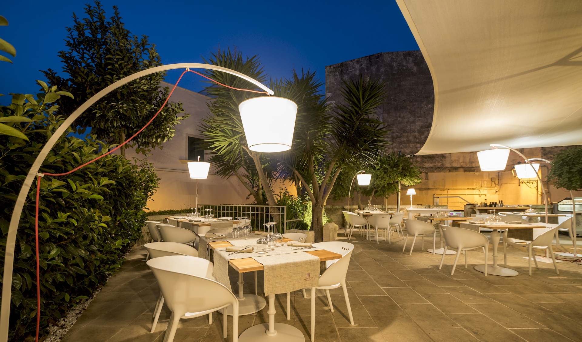 arredamento terrazzo tavoli bianchi lampade bianche arborvitae ristorante lusso otranto realizzato da gruppo rodi 
